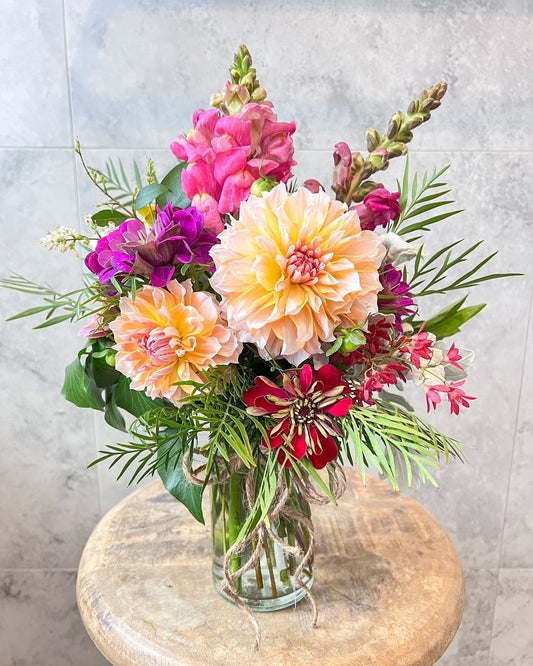 Petite Bloom Jar with a bright and bold arrangement of orange Dahlias, red zinnias, pink snapdragons and seasonal foliage and flowers. A beautiful compact gift, delivered daily to Melton and surrounding suburbs.