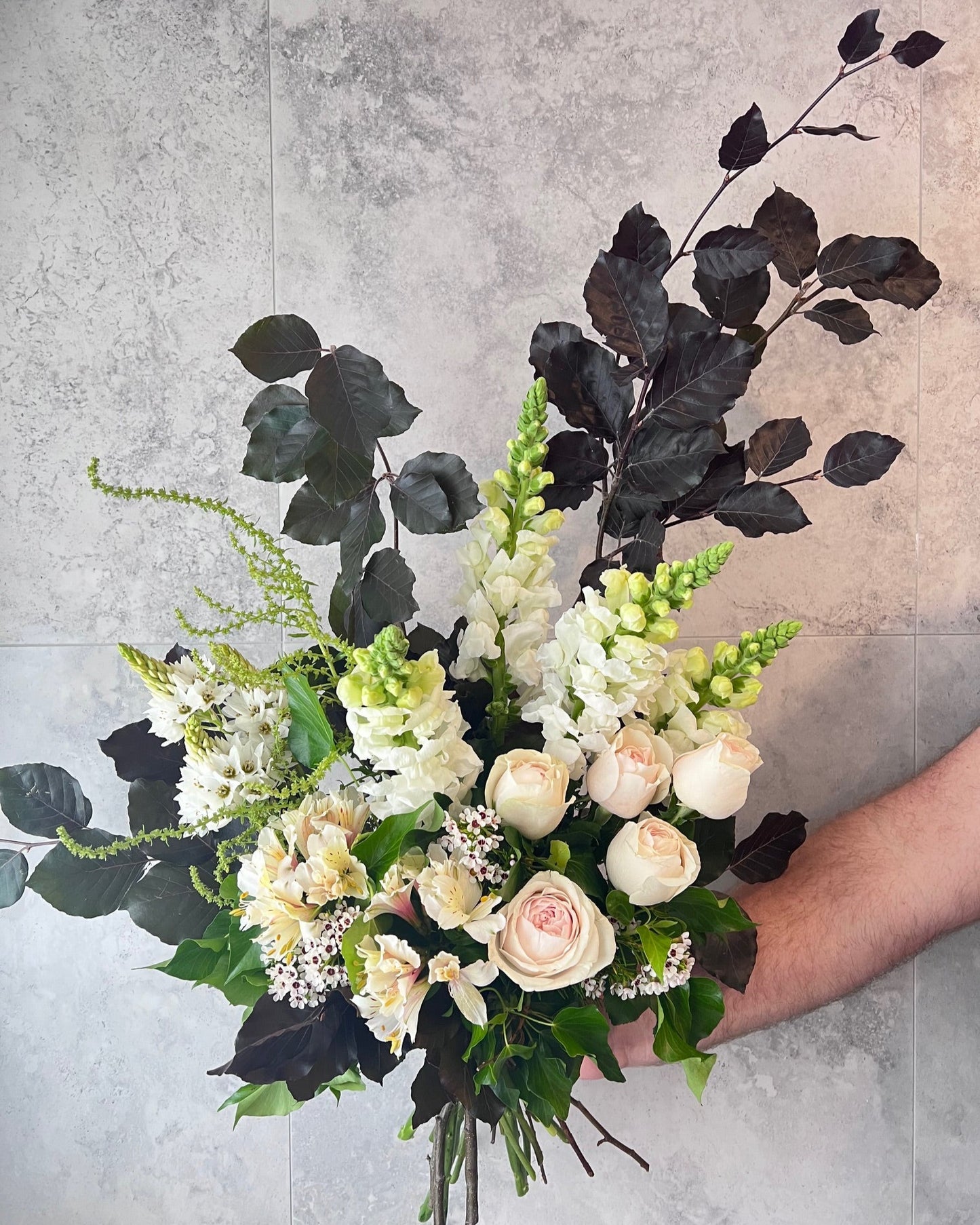 A elegant, hand-tied bouquet of pretty flowers including blush roses, snapdragon and seasonal blooms, delivered fresh across Melton by The Flowered Heart