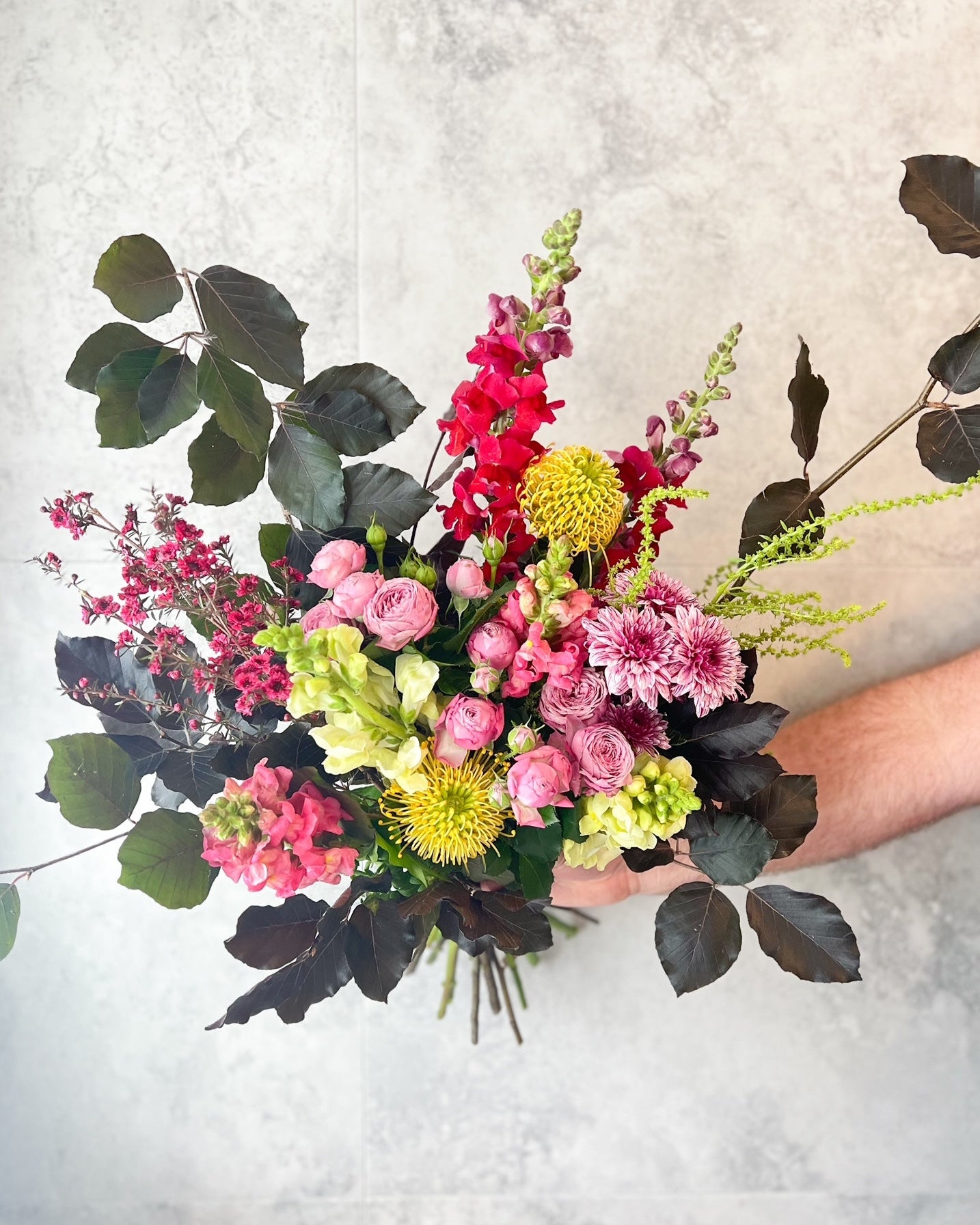 A lush, hand-tied bouquet of bright birthday flowers including pink roses, snap dragons and seasonal blooms, delivered fresh across Melton by The Flowered Heart