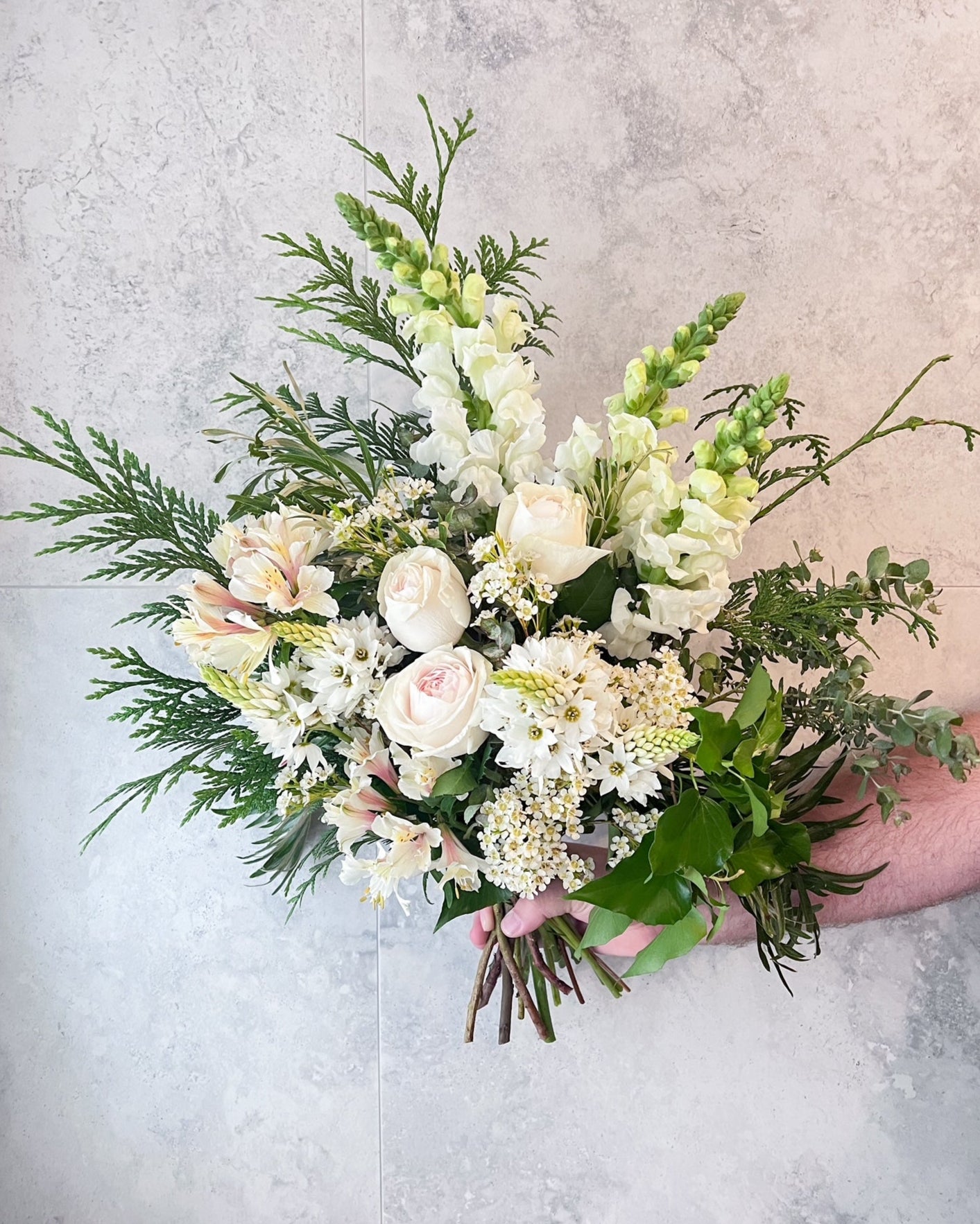A classic and elegant, hand-tied bouquet of white flowers including roses and seasonal blooms, delivered fresh across Melton by The Flowered Heart
