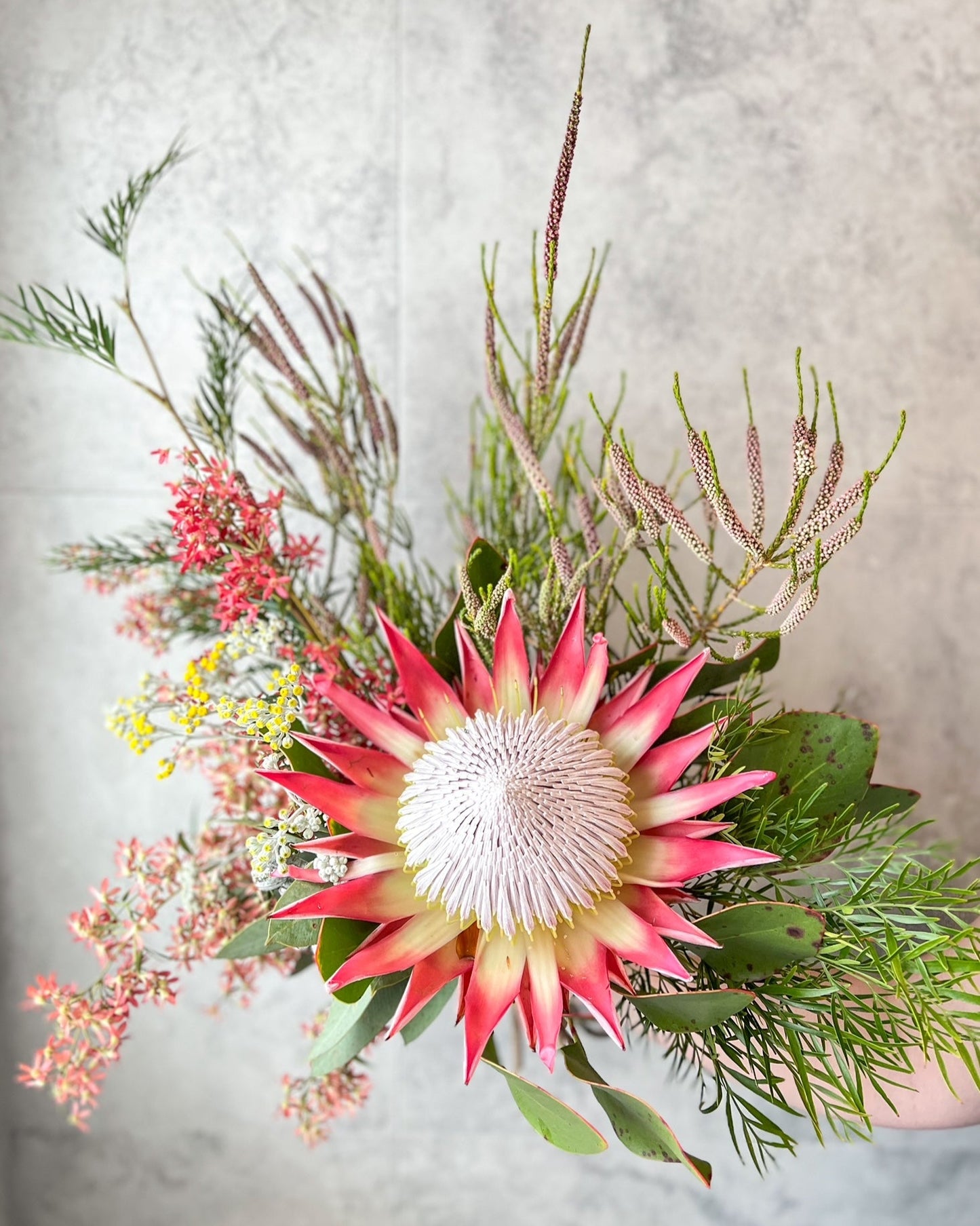 A artful, hand-tied bouquet of native flowers including jaw dropping king protea, christmas bush and seasonal blooms, delivered fresh across Melton by The Flowered Heart