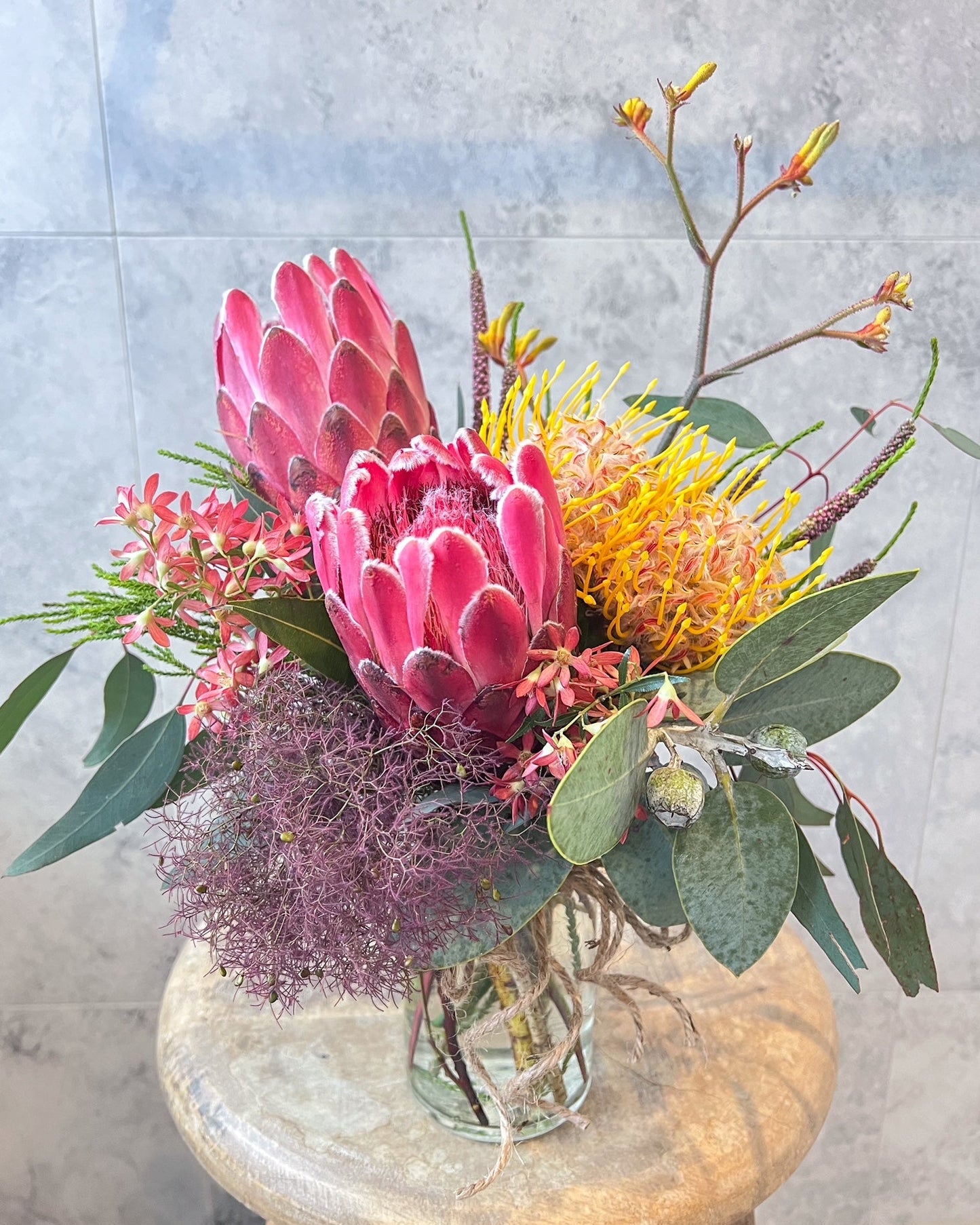 A stunning, jar arrangement of fresh native flowers including protea, smokebush and seasonal blooms, available for same day flower delivery in Melton by The Flowered Heart