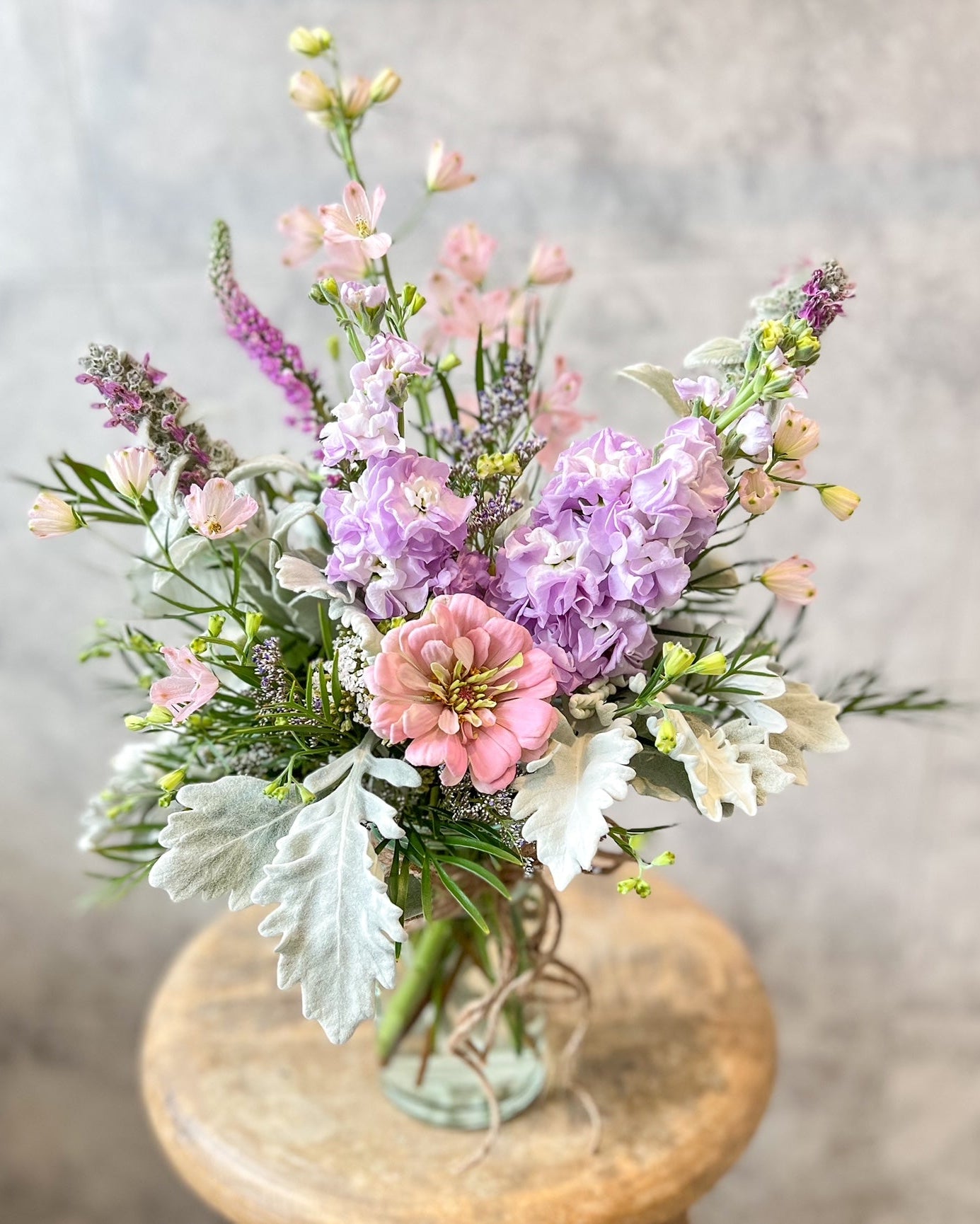 A pastel, jar arrangement of fresh flowers including zinnia, stock and seasonal blooms, available for same day flower delivery in Melton and surrounding areas by The Flowered Heart