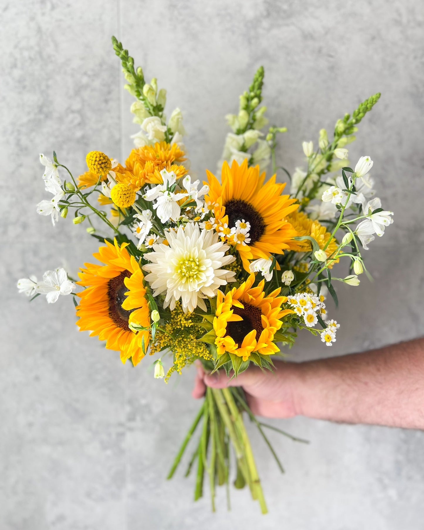 A cheerful and happy, hand-tied bouquet of flowers including sunflower, dahlia, daisy and seasonal blooms, delivered fresh across Melton by The Flowered Heart