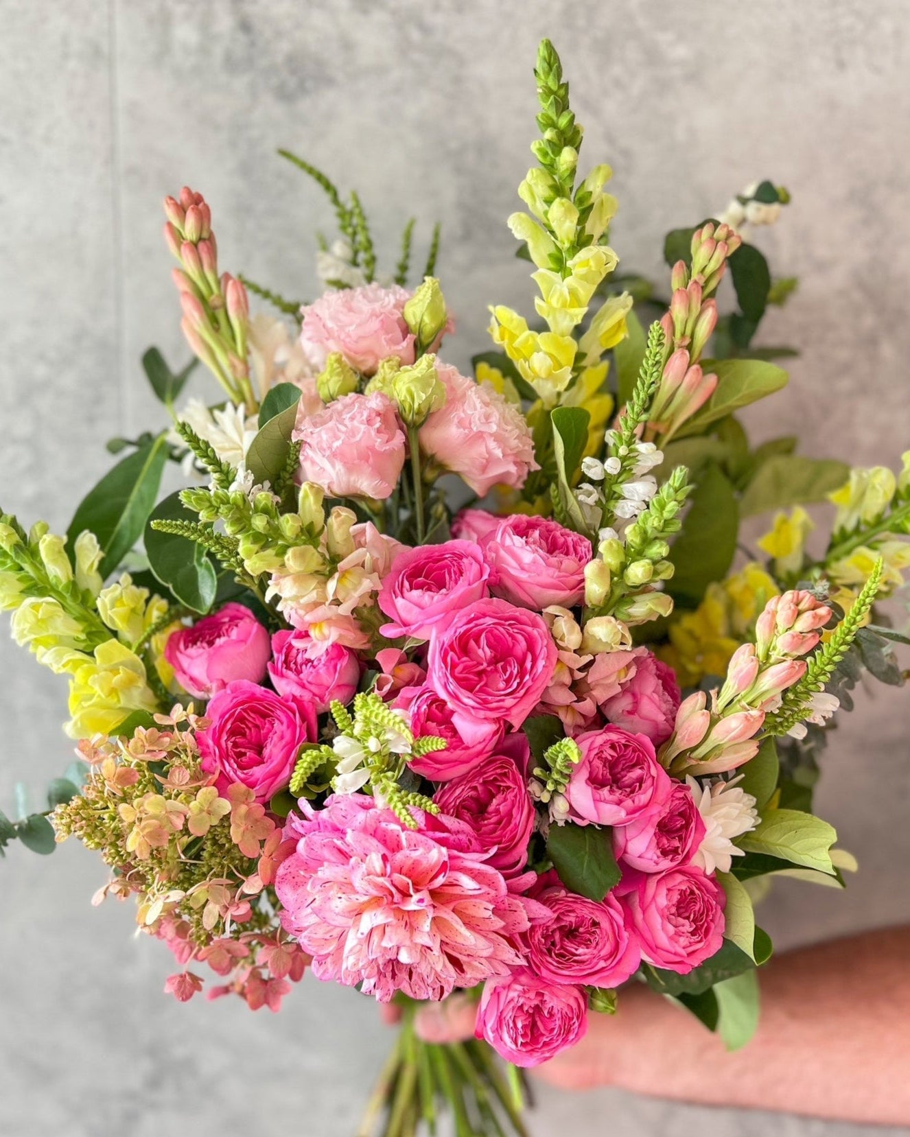A lush, hand-tied bouquet of bright flowers including pink roses, hydrangea, dahlia and seasonal blooms, delivered fresh across Melton by The Flowered Heart