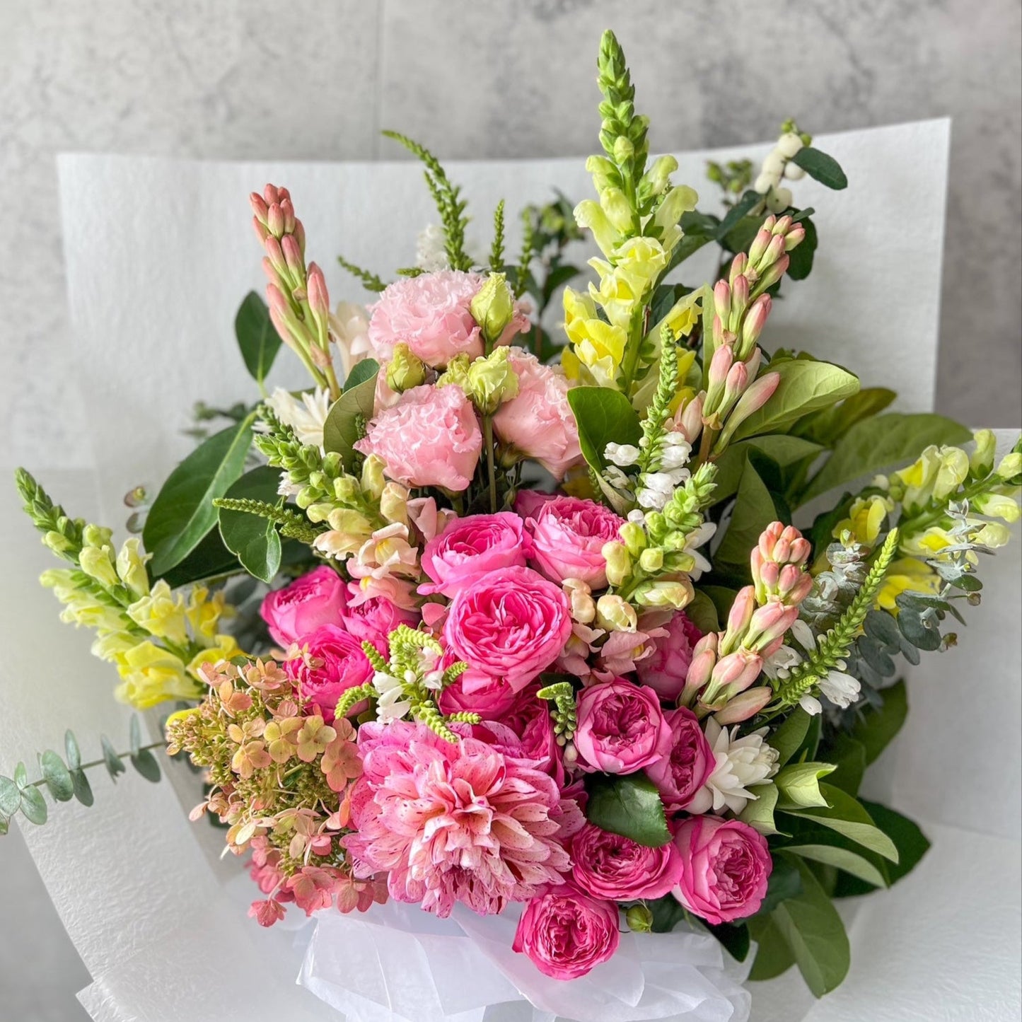 A lush, hand-tied bouquet of bright flowers including pink roses, hydrangea, dahlia and seasonal blooms, delivered fresh across Melton by The Flowered Heart