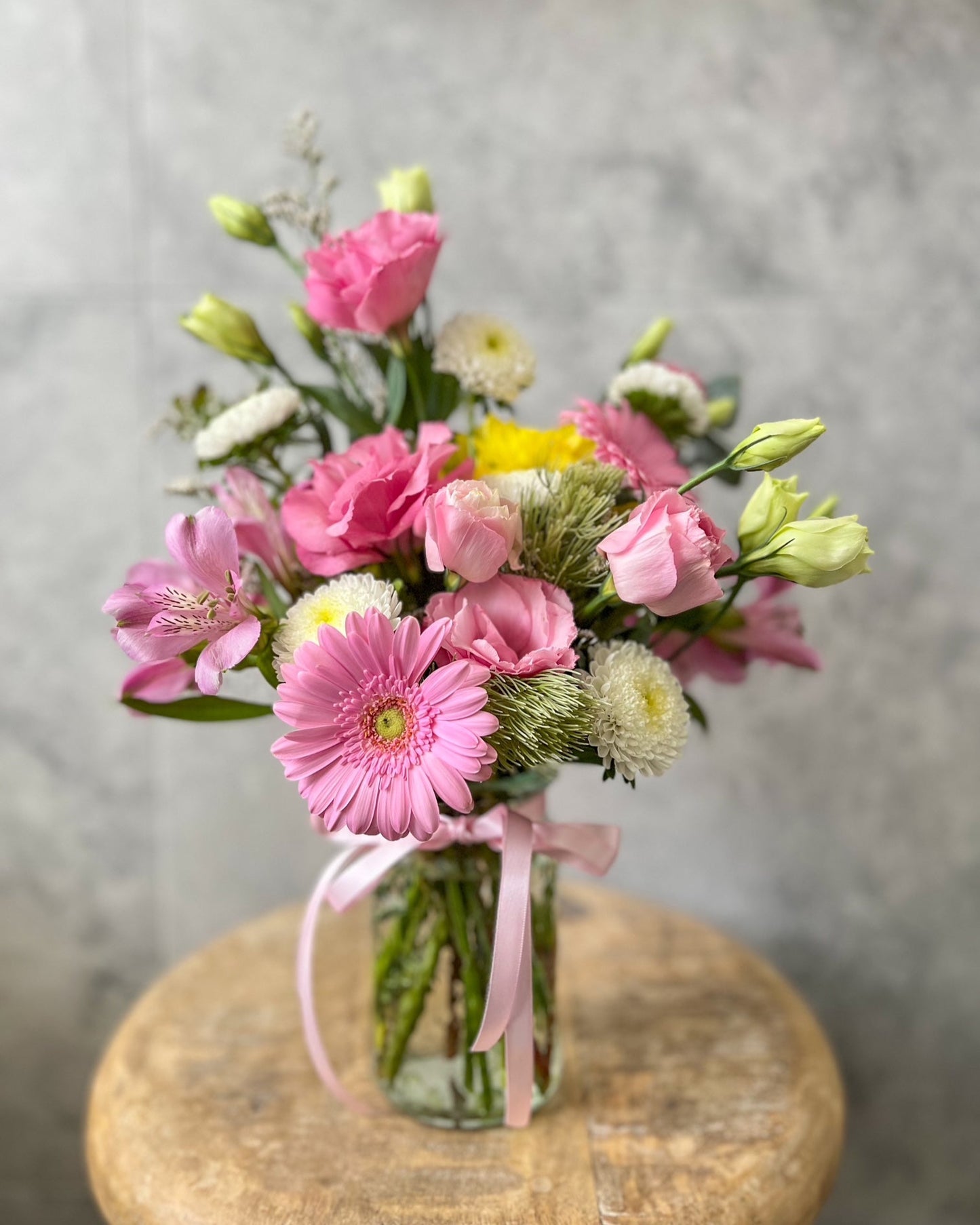 A pastel, jar arrangement of fresh flowers including gerbera, stock and seasonal blooms, available for same day flower delivery in Melton and surrounding areas by The Flowered Heart