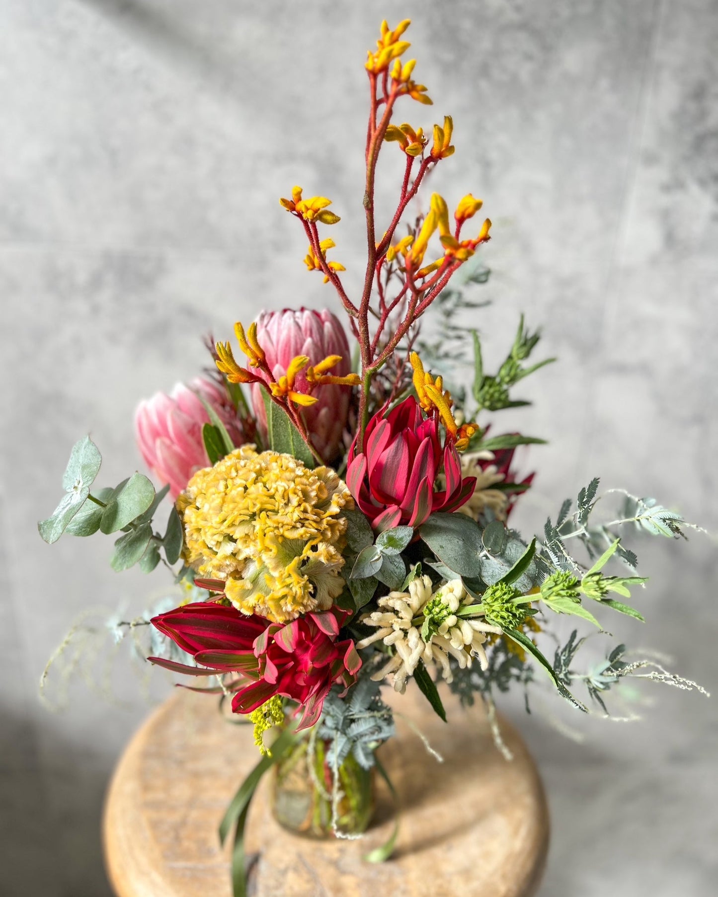A striking, jar arrangement of fresh native flowers including protea, celosia and seasonal blooms, available for same day flower delivery in Melton by The Flowered Heart