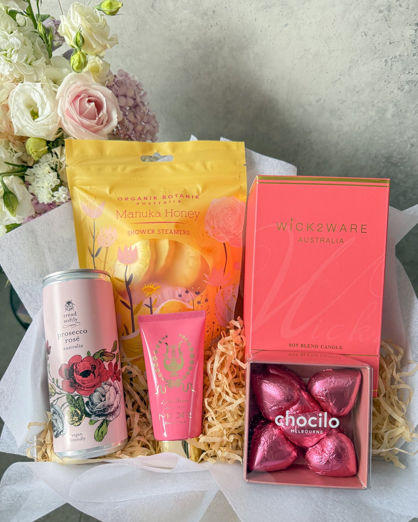 A Little Sunshine gift hamper, with Tread Softly Rose', Chocilo Chocolate Hearts, Mor hand cream, Wick 2 Ware Candle and Organik Botanik shower steamers. A beautiful gift bursting with treats.