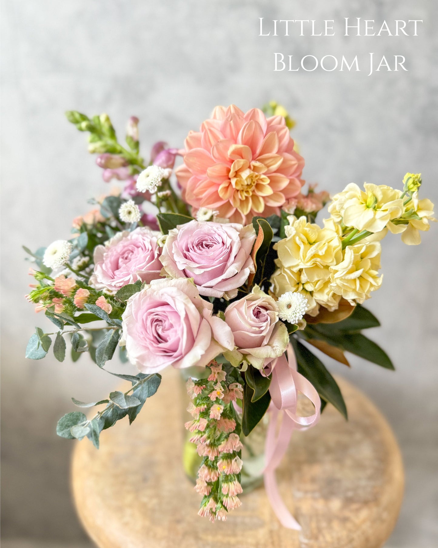 Our Daily flower bouquet Bloom Jar from our Flowers with Heart collection. It features a soft pastel palette and had peach dahlias, yellow stock, mauve snapdragons, spray roses and seasonal flowers.