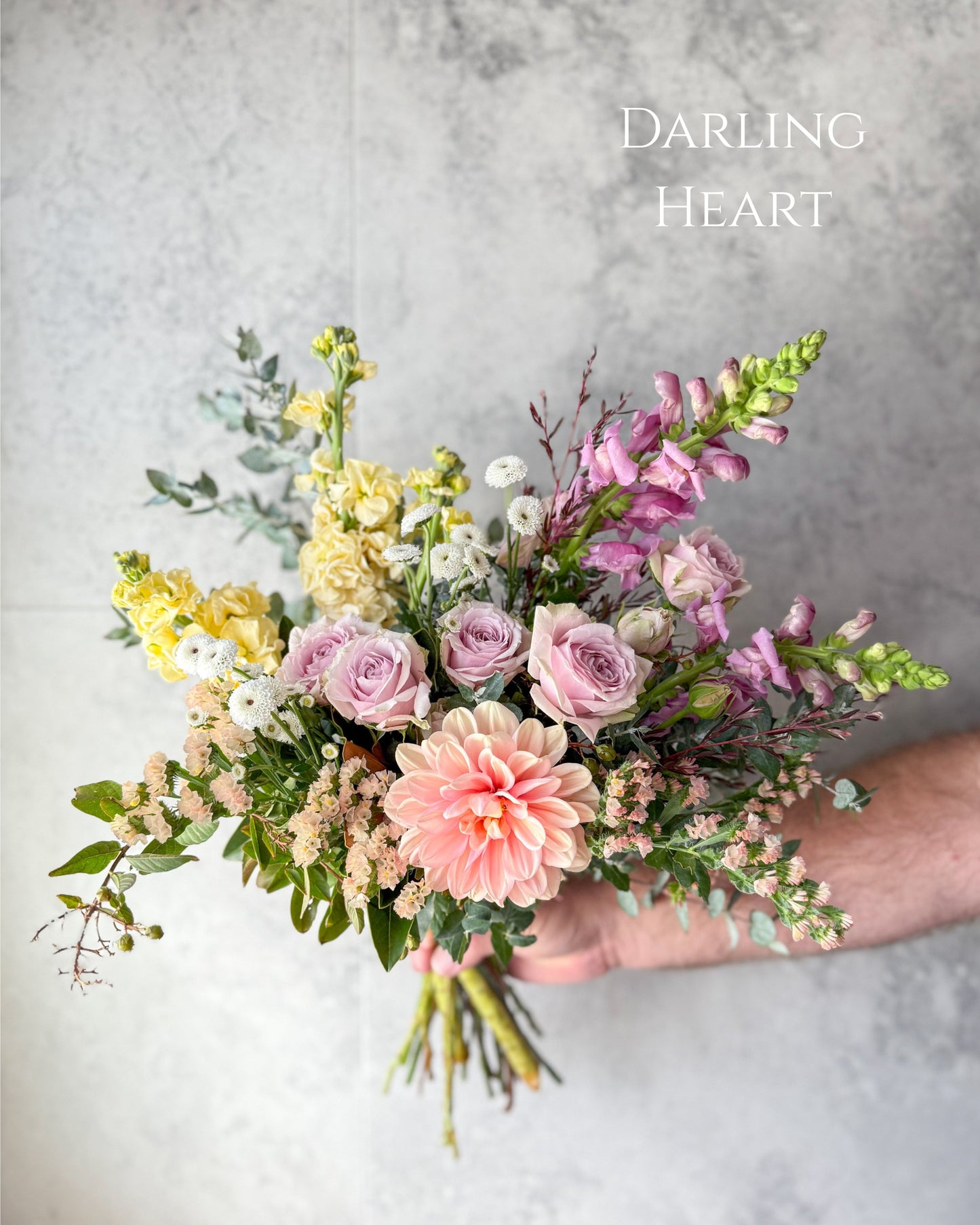 Our medium sized Daily flower bouquet from our Flowers with Heart collection. It features dreamy pastel flowers and had peach dahlias, yellow stock, mauve snapdragons, spray roses and seasonal flowers.